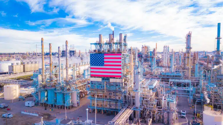 an industrial factory scene with a blue sky and an American flag
