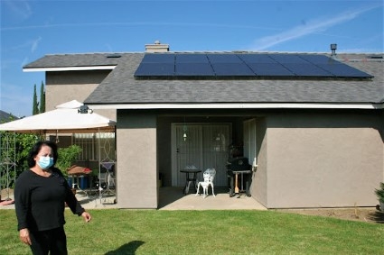 Lupe in front of her solarized house