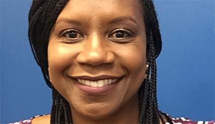 Smiling woman with braided hair against a blue background