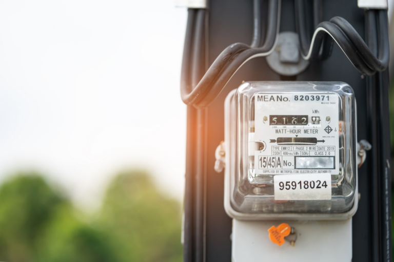 Electric meter displaying 5162 kilowatt-hours with MEA number 8203971 mounted on wooden pole