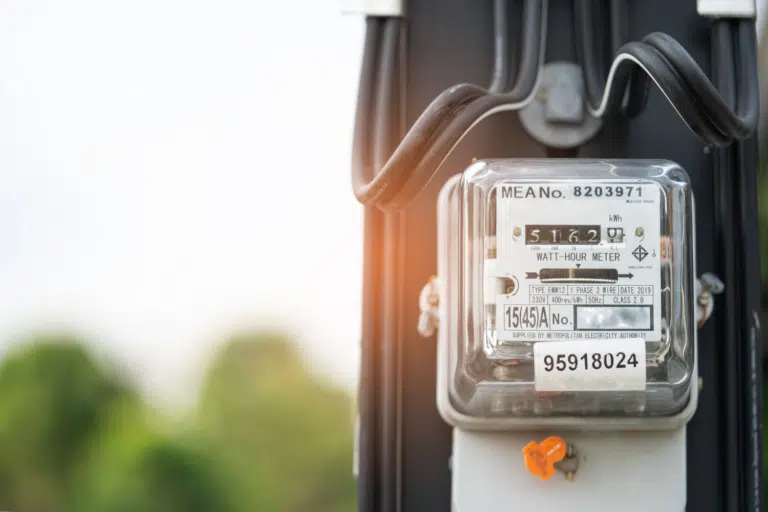 Electric meter displaying 5162 kilowatt-hours with MEA number 8203971 mounted on wooden pole