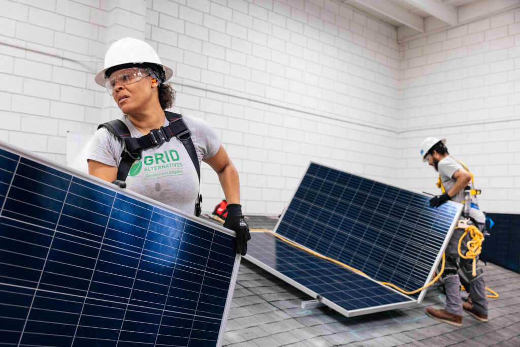 one installer carrying a solar panel