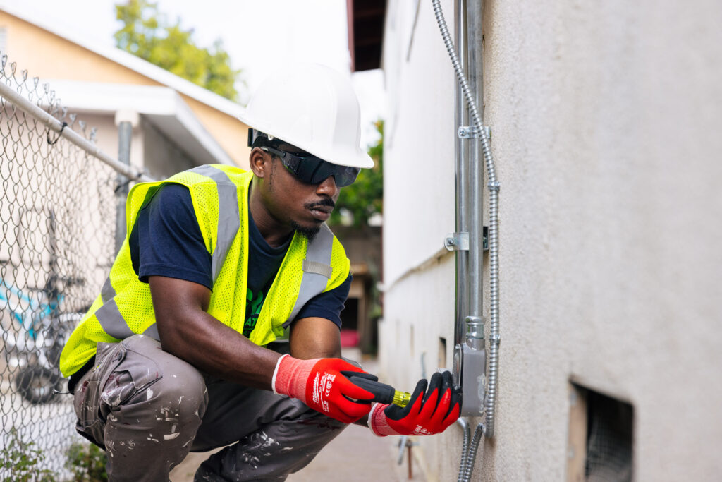 Man installing electrical, wearing safety equipment