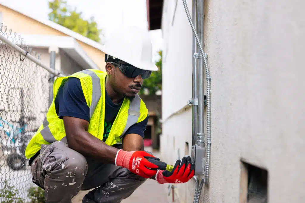 Man installing electrical, wearing safety equipment