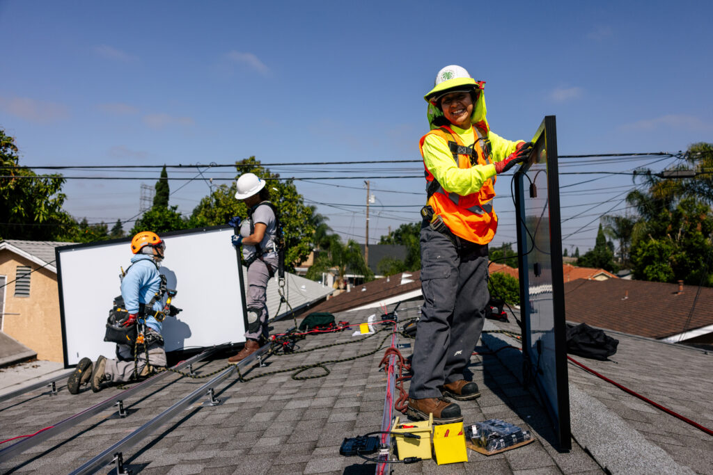 installers on roof holding solar panels