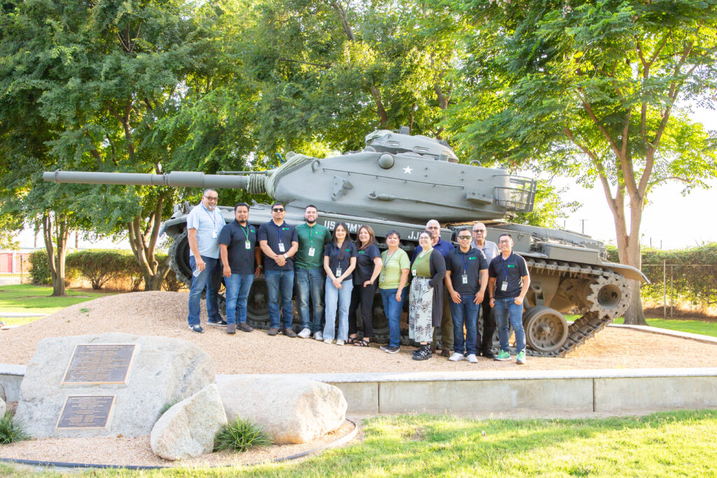 GRID Outreach Staff posing for a picture in front of retired army Tank