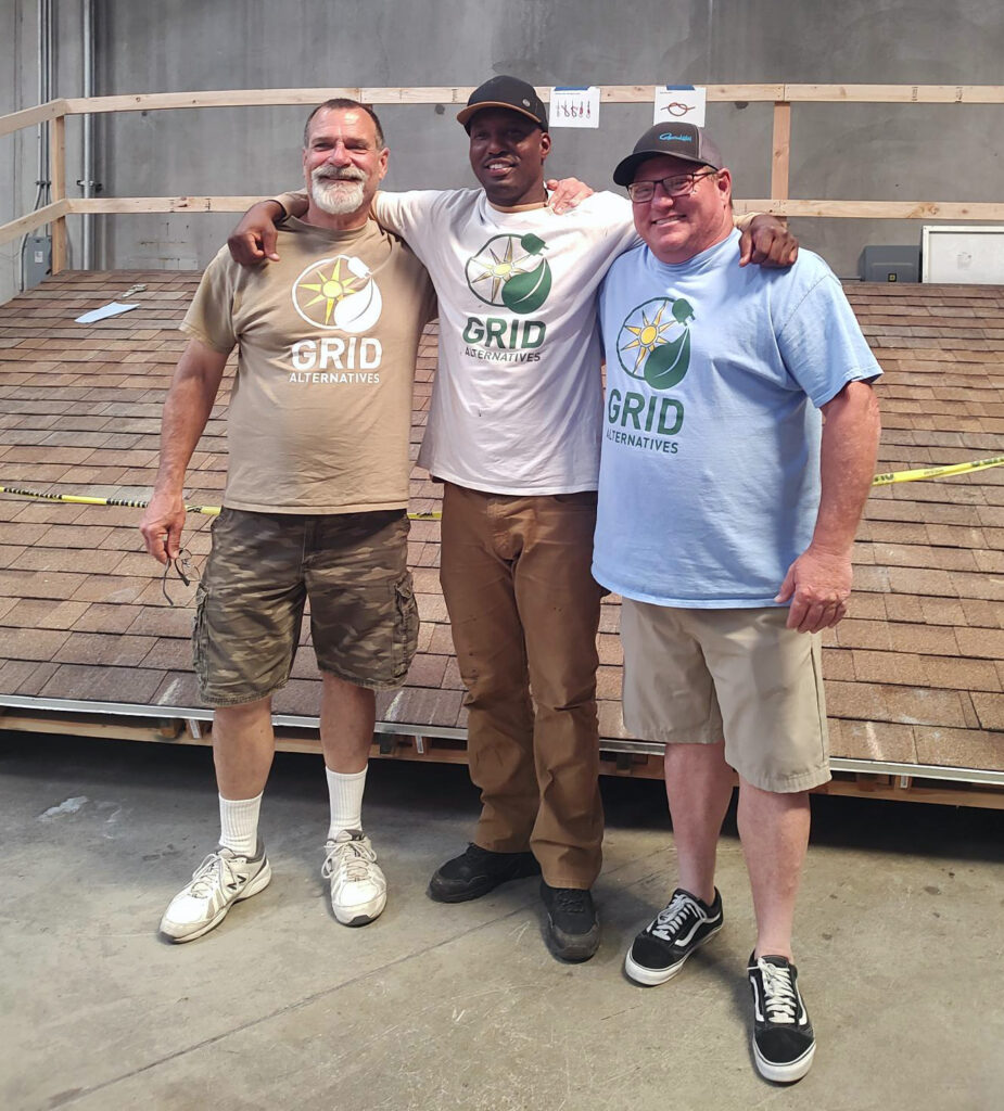 Mark (center) with Neil Warren, Senior Solar Installation Training Officer (left), and Dan Glasow, Construction Director (right), at the training roof in the CTTC.