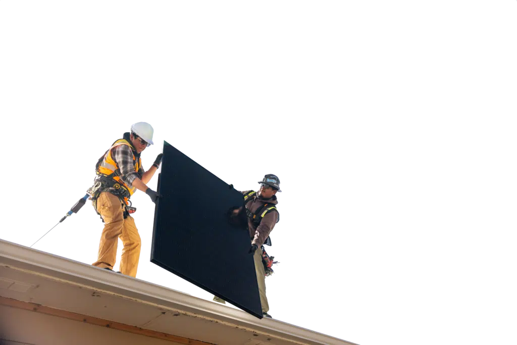 two people holding solar panels on roof