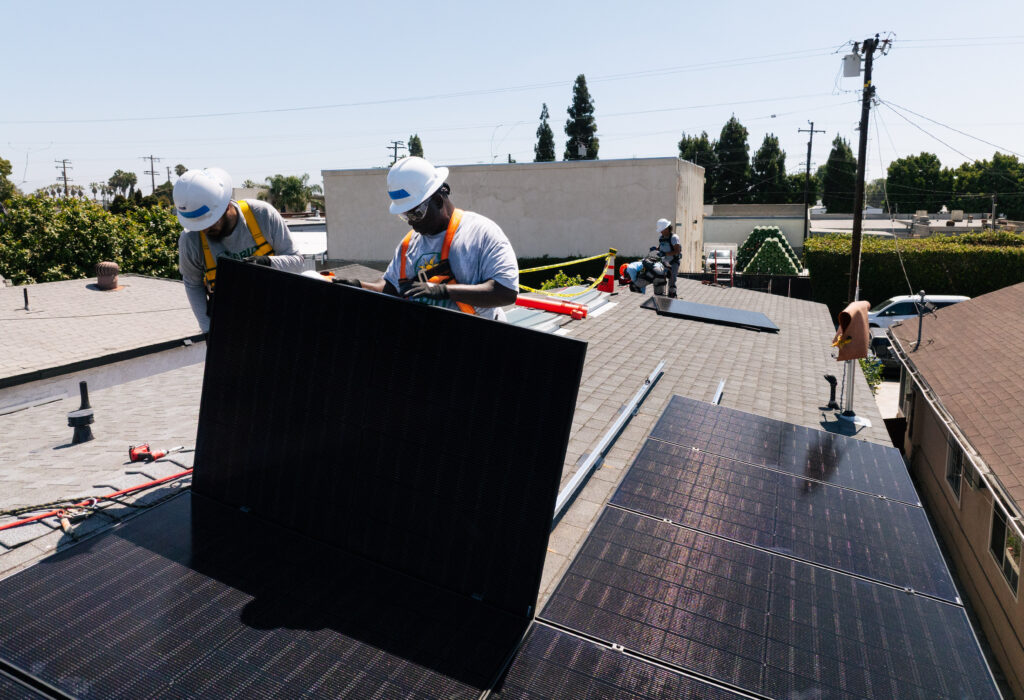 Workers installing solar panels on a residential rooftop in Southern California